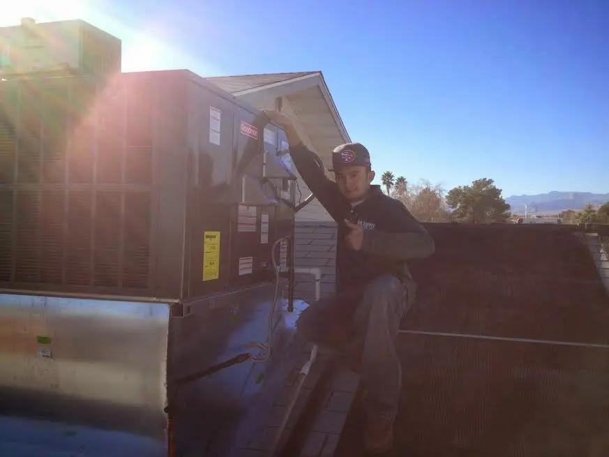 HVAC technician performing Air Duct Cleaning on a rooftop unit in Dover